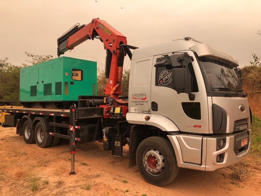 Munck descarregando gerador em área rural